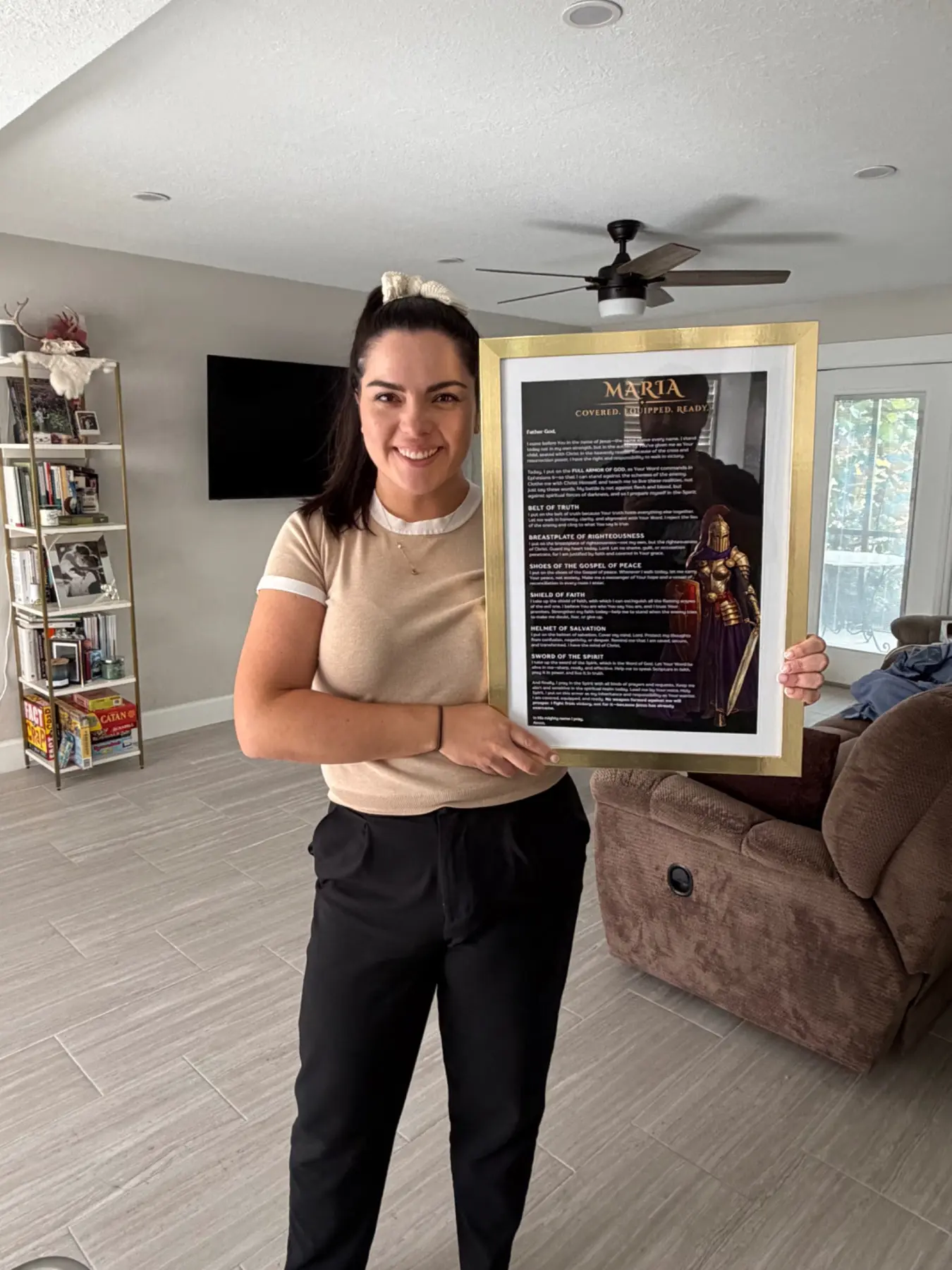 Maria holding her personalized Armor of God prayer in a gold frame